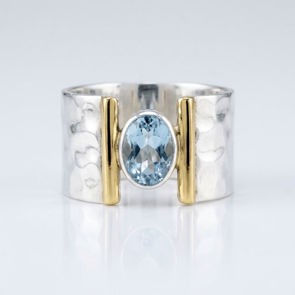 Anel moderno de prata, ouro e topázio com design elegante, da marca Rose & Oliver, mostrando detalhes da joia.