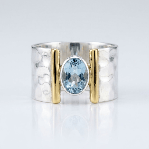 Anel moderno de prata, ouro e topázio com design elegante, da marca Rose & Oliver, mostrando detalhes da joia.