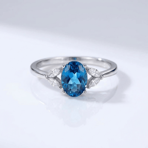 Anel ajustável com topázio oval azul prateado da Rose & Oliver, destaque para a pedra brilhante e a moldura elegante.