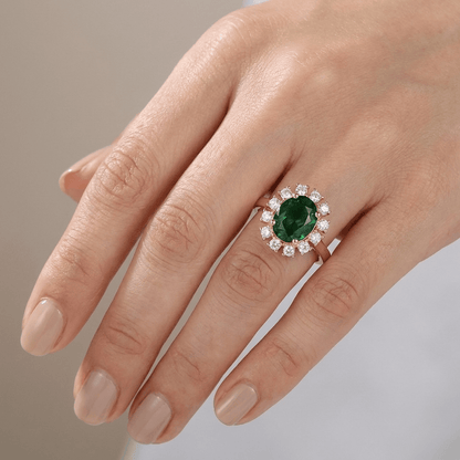 Anel de ouro rosé com diamantes e esmeraldas em halo, ajustável, da marca Rose & Oliver, detalhe de joia elegante e sofisticada.