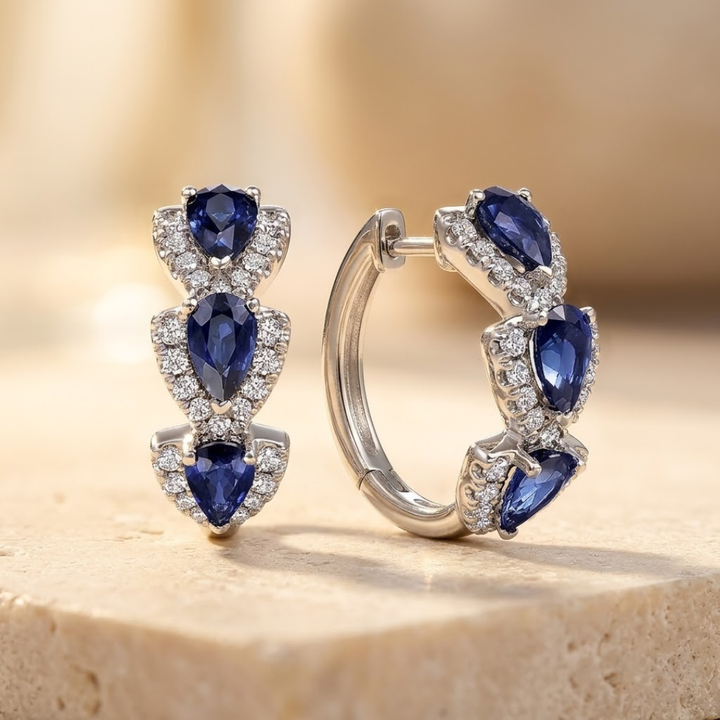 Brincos de argola prateados com halo de safira, da marca Rose & Oliver, detalhes brilhantes e elegantes.