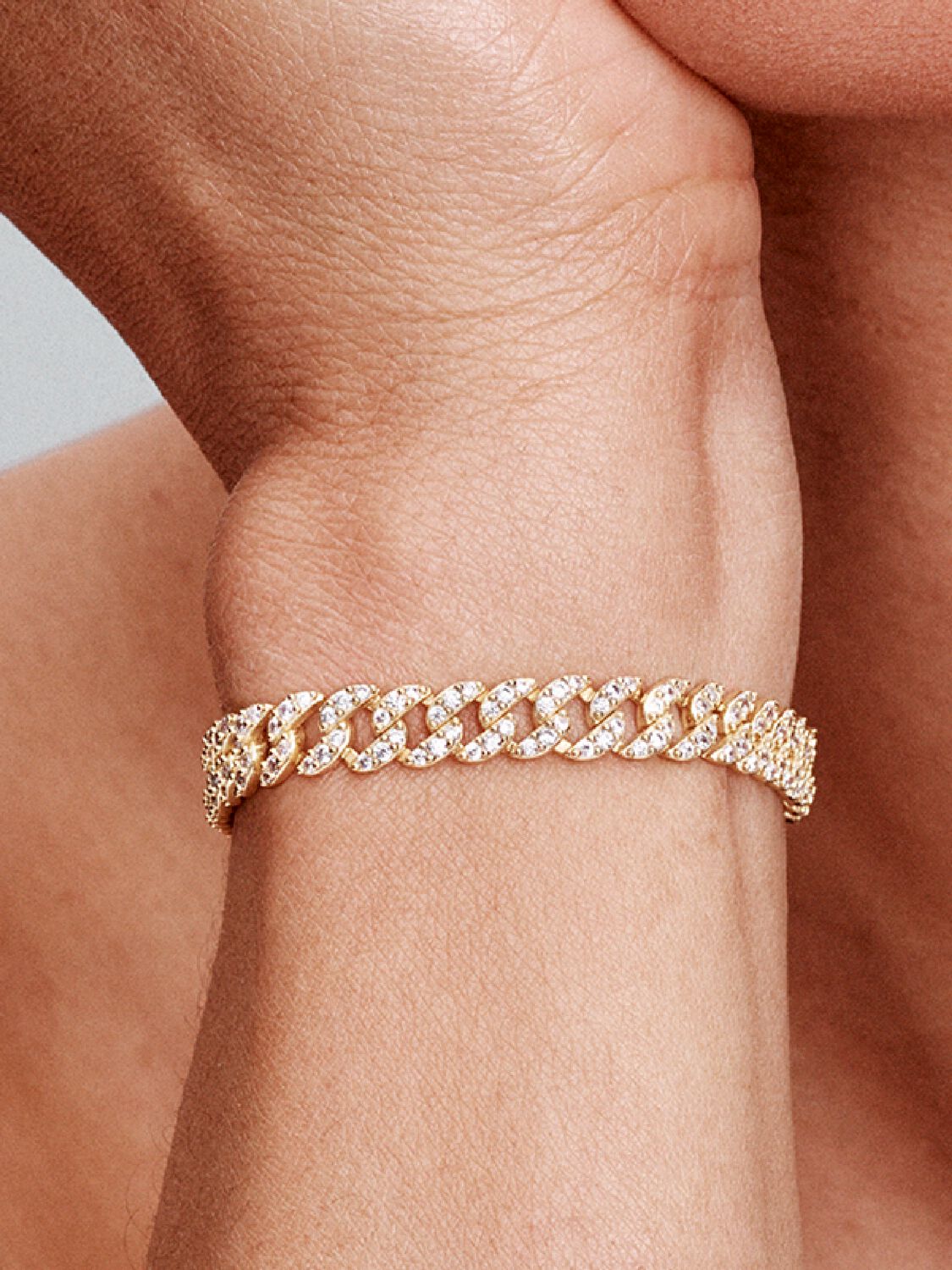 Pulseira Cuban Pave Rose & Oliver em ouro, detalhes brilhantes e acabamento elegante, em close-up.
