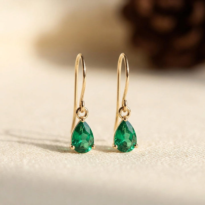 Brincos de gota com esmeraldas verdes em ouro, modelo de argolas da Rose & Oliver, detalhes elegantes e sofisticados