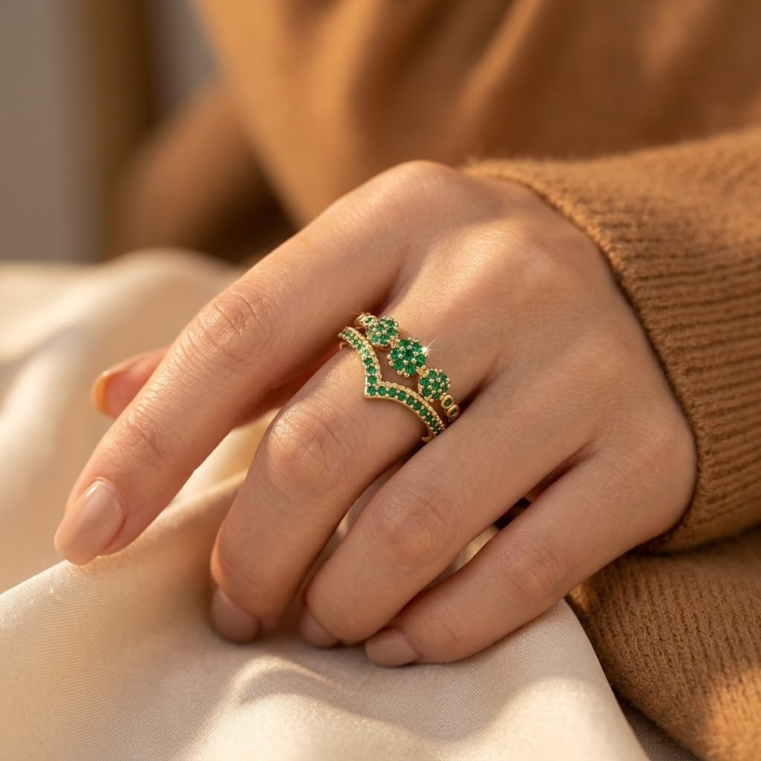 Anel dourado com cluster de esmeraldas verdes e detalhes em ouro, joia elegante da marca Rose & Oliver.
