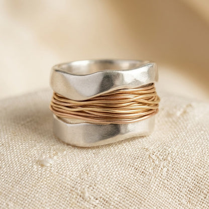 Anel Rose & Oliver de prata e ouro envolvido, com design elegante e acabamento brilhante.