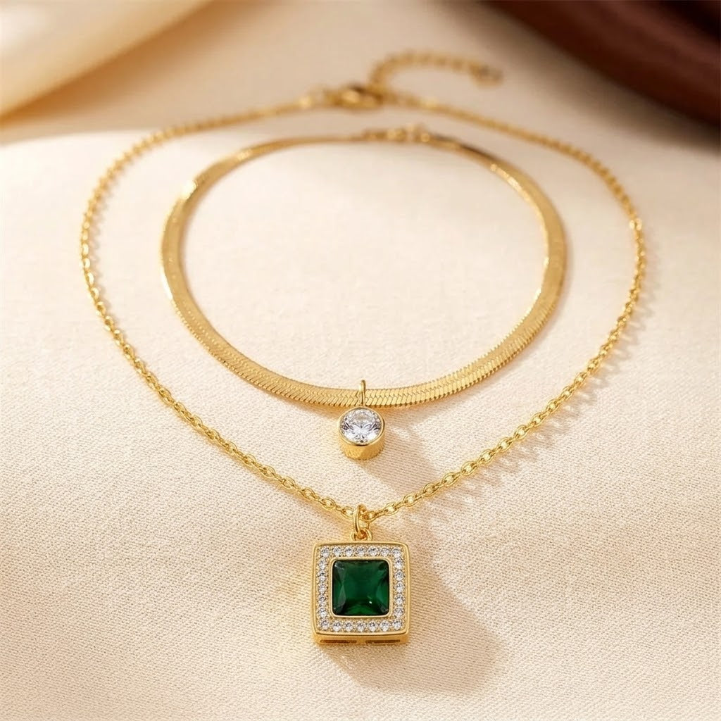 Colar dourado com esmeraldas em camadas, joia elegante da marca Rose & Oliver, com detalhes refinados e brilho vibrante.