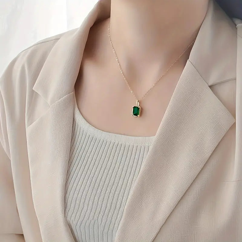 Colar retangular com halo de esmeralda e acabamento dourado, da marca Rose & Oliver, com destaque para o pingente elegante.