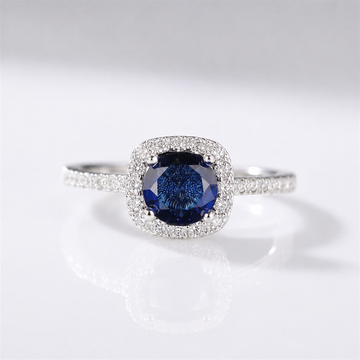 Anel de safira azul em corte cushion com halo de diamantes, produzido pela Rose & Oliver.