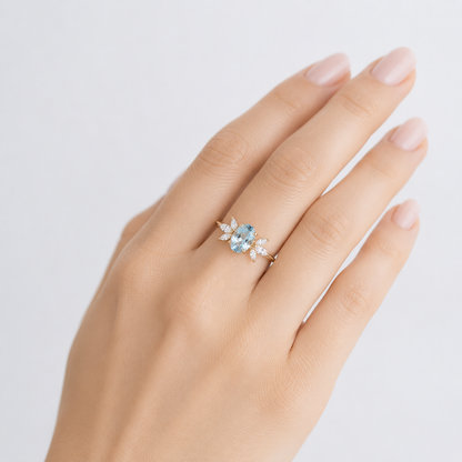 Anel de ouro com pedra aquamarine marquise brilhante, da marca Rose & Oliver, exibido com destaque na imagem.