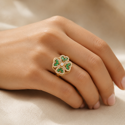 Anel floral de ouro com esmeraldas verdes, design delicado e elegante, da marca Rose & Oliver.
