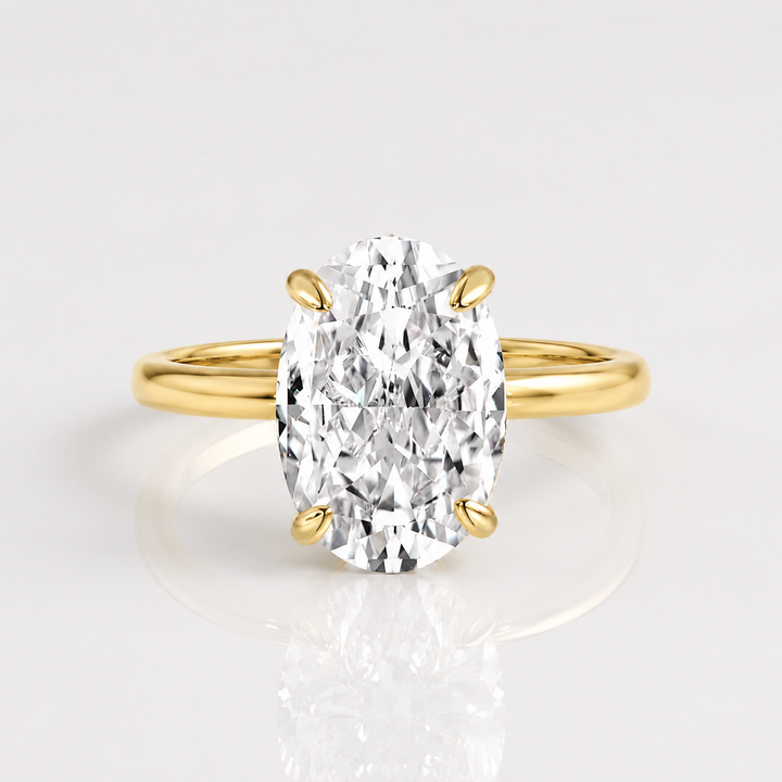 Anel de ouro com diamante oval solitário da Rose & Oliver, destacando o design elegante e a pedra central brilhante.