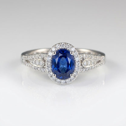Anel vintage Rose & Oliver com halo de safira azul e detalhes em prata, destaque para o design elegante e pedra central brilhante.
