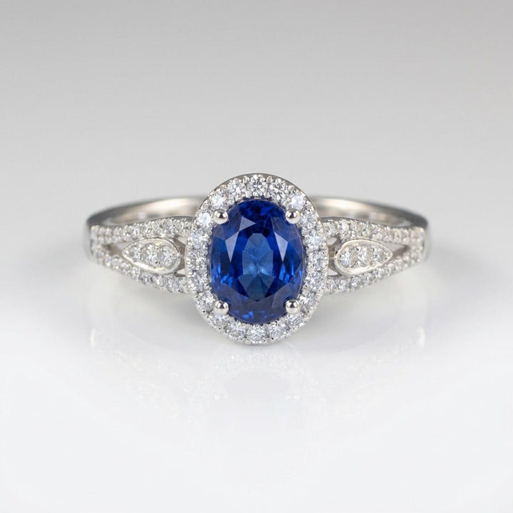 Anel vintage Rose & Oliver com halo de safira azul e detalhes em prata, destaque para o design elegante e pedra central brilhante.