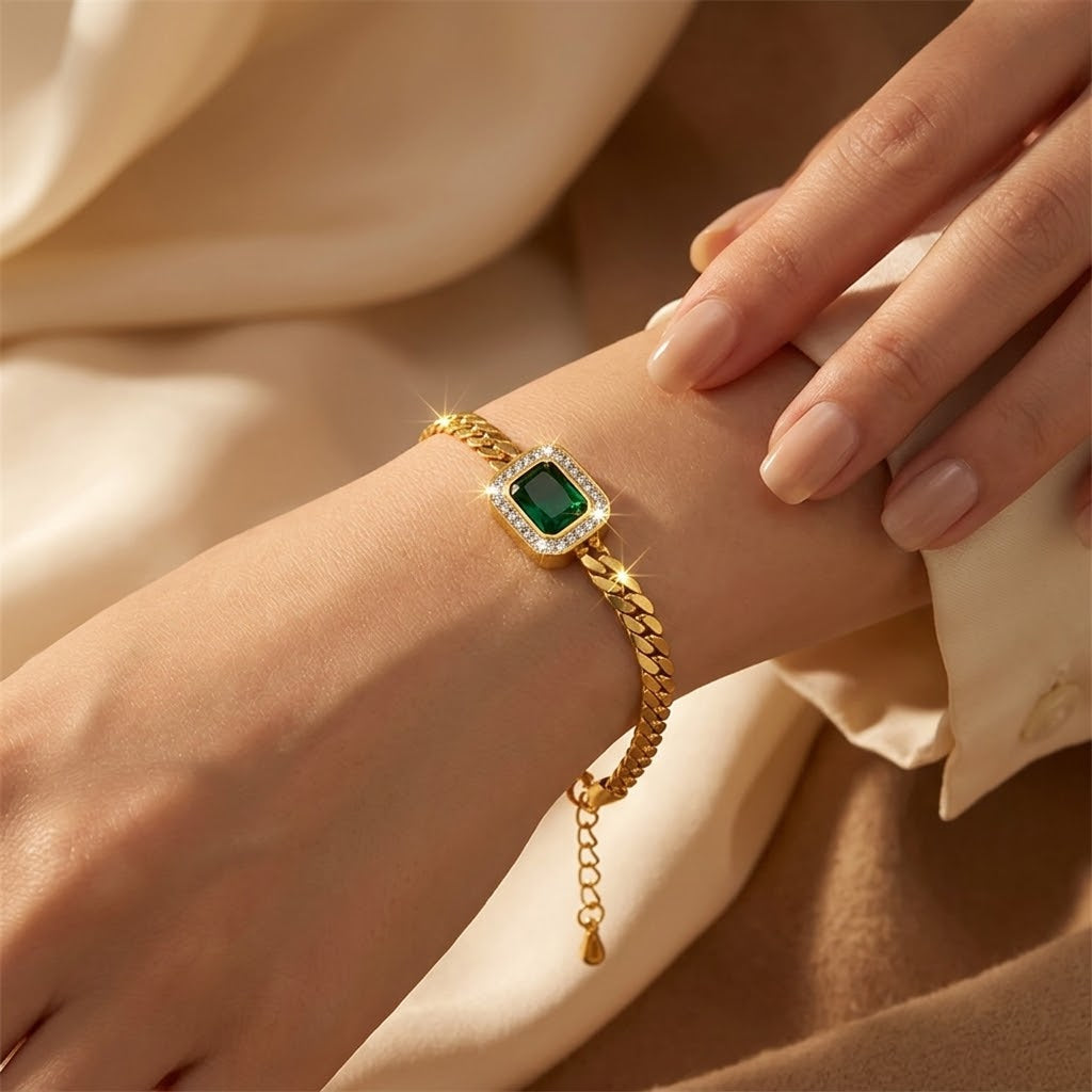 Pulseira de corrente com detalhes em ouro e esmeralda, da marca Rose & Oliver, mostrando o design elegante e brilhante.