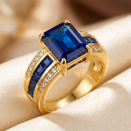 Anel Rose & Oliver com pedraria safira azul em corte quadrado e acabamento em ouro 18k.