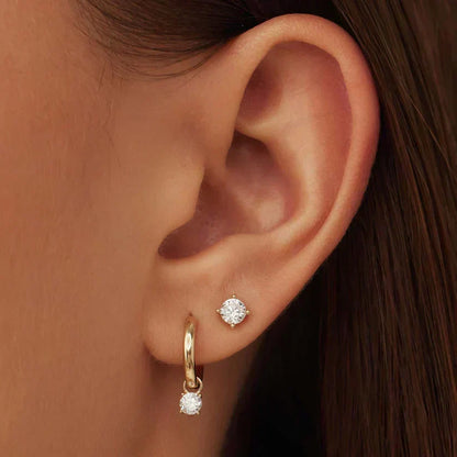 Brincos de metal dourado Larmes™ com pedra, estilo clássico, da marca Rose & Oliver, em close na imagem.