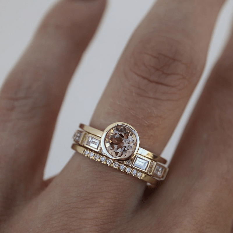 Anel de solteiro com aro dourado e acabamento em bezel, da marca Rose & Oliver, exibido em fundo neutro.