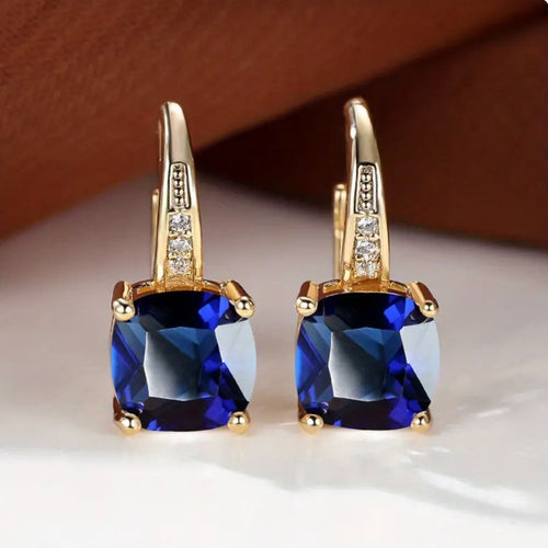 Brincos de argola com pedra safira mística, feitos pela Rose & Oliver, com acabamento elegante e detalhes brilhantes.